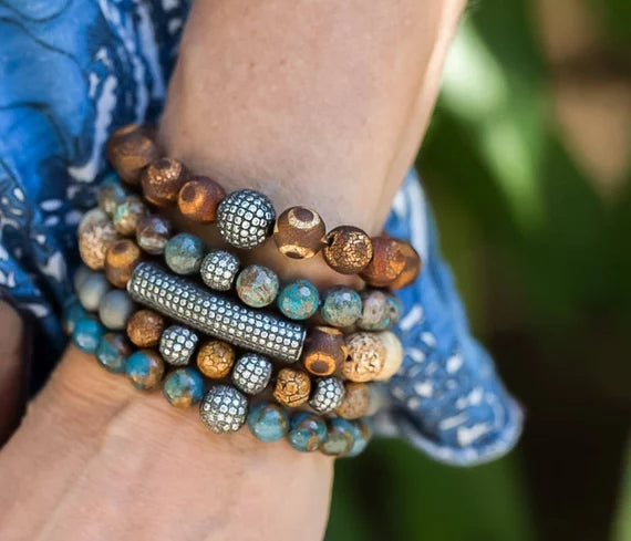 P10256 SET DE 5 PULSERAS DE MUJER DE CUENCAS MARRONES, AZULES Y DIJES METçLICOS.