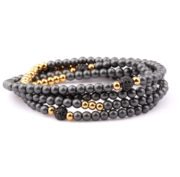 P9671 PULSERA ENROLLABLE DE CUENCAS HEMATITA Y DORADO CON CIRCONES.