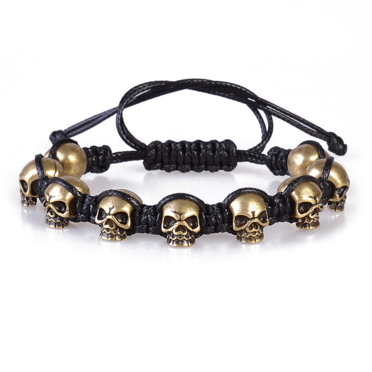 P95803 PULSERA DE CALAVERA DORADO Y TRENZADO NEGRO AJUSTABLE.